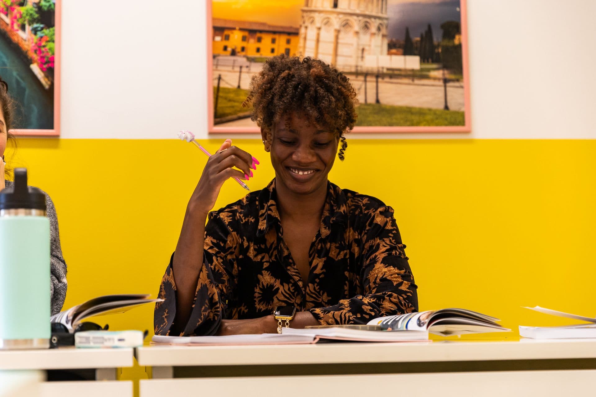 A smiling learner at a desk in an English class