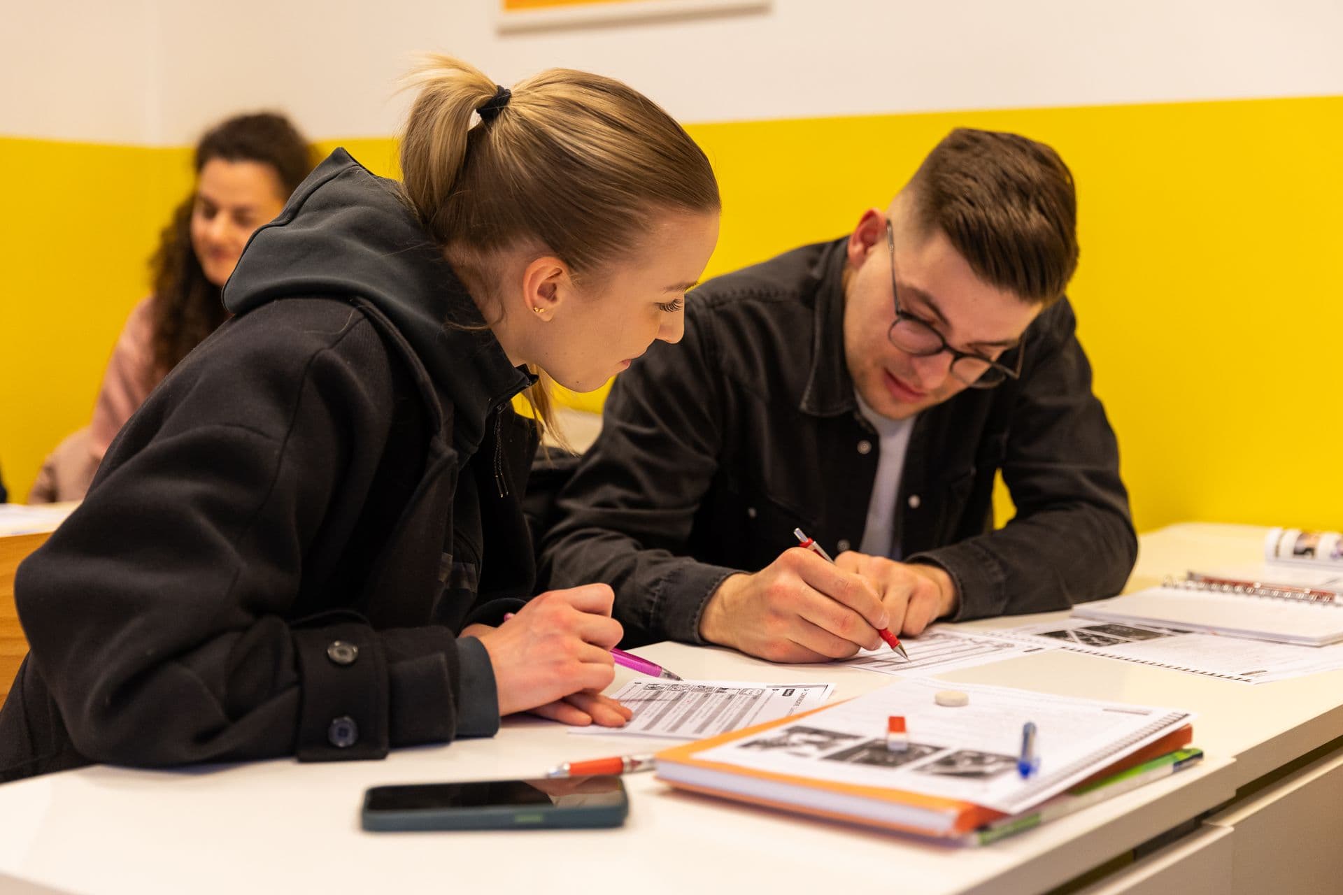 Two students writing at a desk