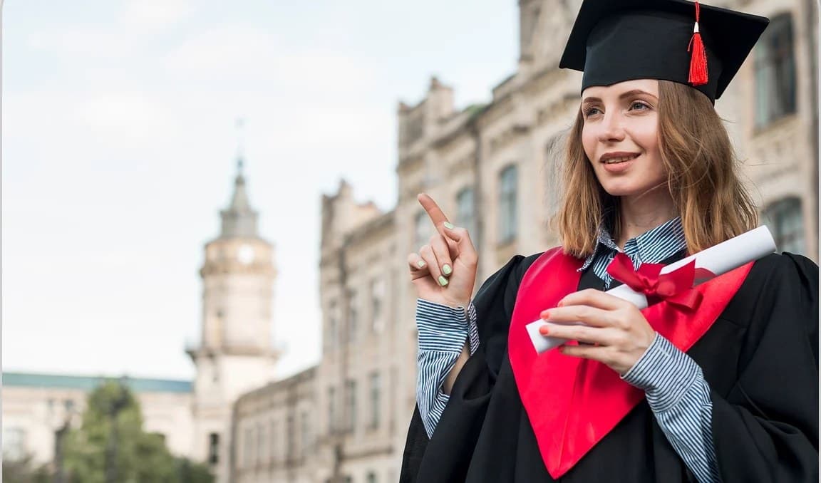 Studentica u svečanoj odori s diplomom pred sveučilišnom zgradom