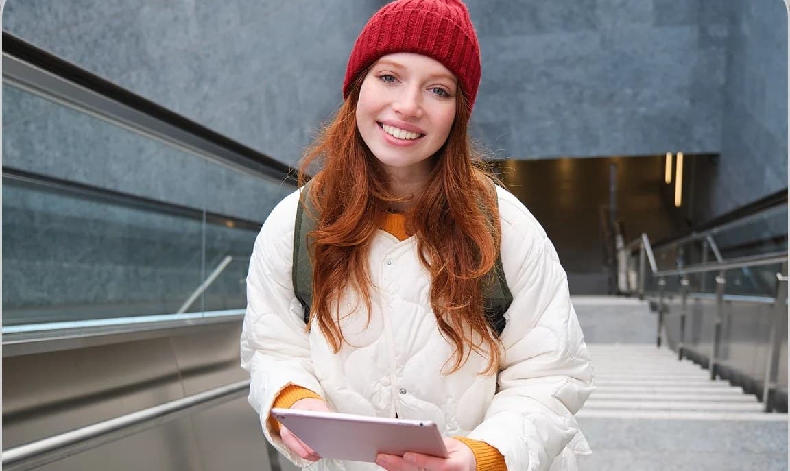 Studentica s tabletom na stubama sveučilišne zgrade